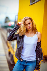 girl with freckles without makeup, near the yellow train at the station