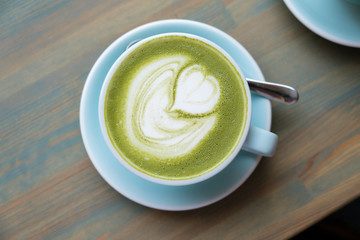 Matcha latte with vegetable milk in a blue mug.
