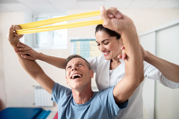 Obraz premium Happy man is doing stretching rehab exercises