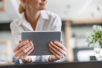 Beautiful adult woman is holding digital tablet