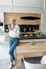 Smiling lady with hot drink in hands