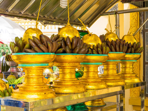 YANGON, MYANMAR - JANUARY 4, 2018: Bananas and coconuts painted of gold outside the Botataung Pagoda.