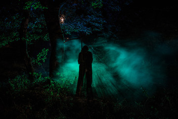Death with a scythe in the dark misty forest. Woman horror ghost holding reaper in forest