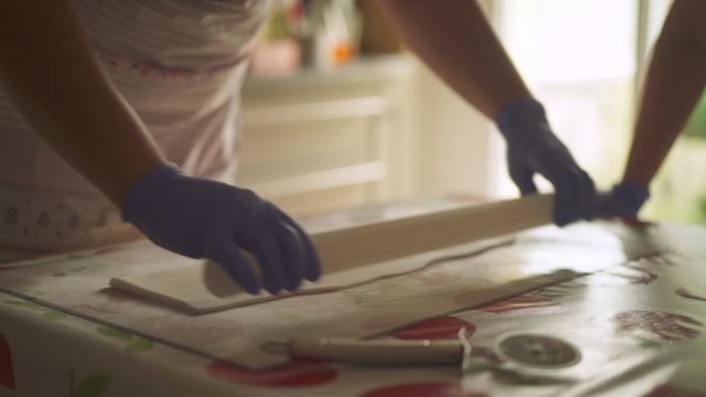 Celebration cake making, workers rolling out fondant icing in workshop