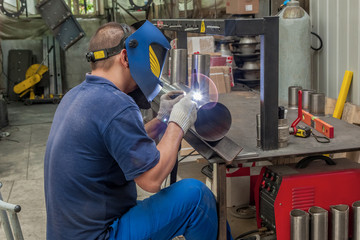 Closeup of man wearing mask welding in a workshop