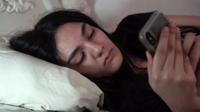 Girl texting on her phone in bed