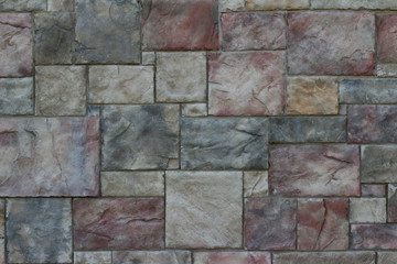Colorful modern marble-like tile wall texture with blocks in varying hues of rose red, blue, and gray