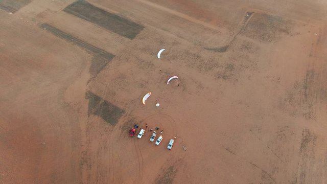 Paragliders parked and set up preparing for paramotoring sports in Granite field, South Australia