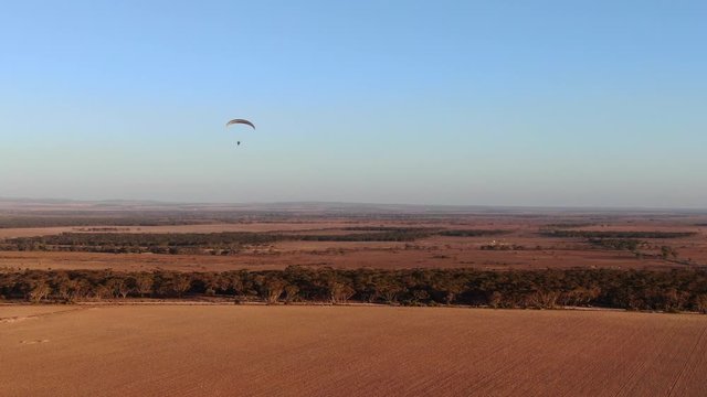 Nice view of parachutist paramotoring enjoying flying in the air