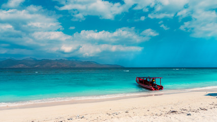 Cloudy morning at south east beach on Gili Trawangan. Light rays penetrating the clouds. Gili Islands, Indonesia.