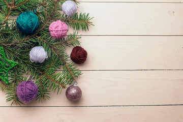 Christmas tree and yarn balls as decorations on wooden background