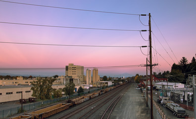 Fototapeta na wymiar Power lines and rail road tracks looking east at sunset in North Portland, Oregon