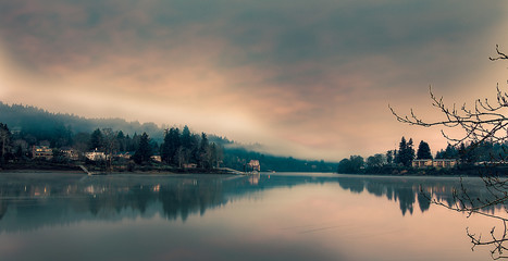 Fototapeta premium Riverwood and Milwaukie on opposite sides of the Willamette River, Cloudy sky, still water, long exposure, seen from Milwaukie Bay Park at dawn
