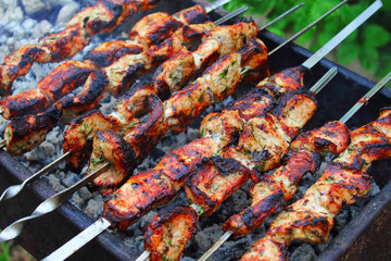 Cooking meat skewers on a roasting pan. Close-up. Background.