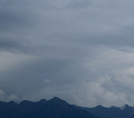 Düstere graue Regenwolken über den Alpen
