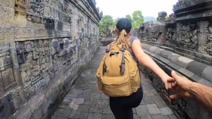 Tourists holding hands exploring the Borobudur temple in Java island,Indonesia