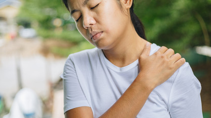 Young asian woman has pain in shoulder , health care concept