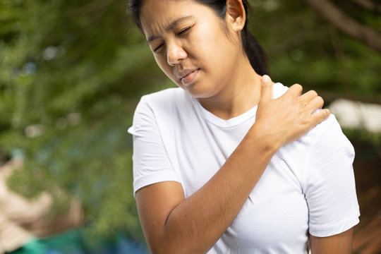Young asian woman has pain in shoulder , health care concept