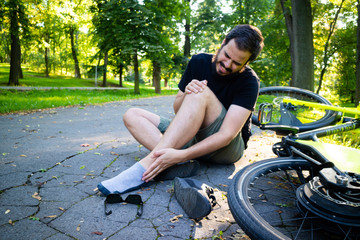 Man on the floor with injured ankle after an accident with electric bicycle