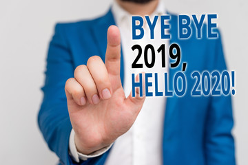 Word writing text Bye Bye 2019 Hello 2020. Business photo showcasing saying goodbye to last year and welcoming another good one Businessman in blue suite and white shirt pointing with finger in empty