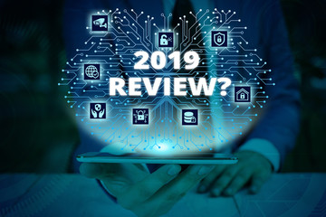 Writing note showing 2019 Review Question. Business concept for remembering past year events main actions or good shows Male wear formal work suit presenting presentation smart device