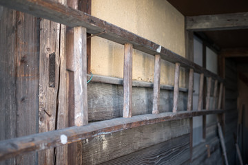 Fototapeta na wymiar 古い日本の小屋の壁に取り付けられたはしご
