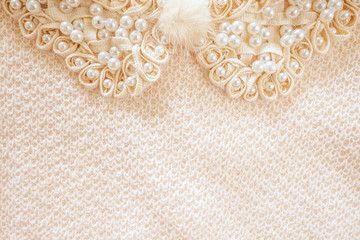 Beaded ribbon and woven fabric background with soft fluffy button decoration off white in colour and shot from above