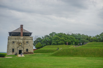 Fototapeta na wymiar Porter, New York, USA: Visitors at the North Redoubt on the 23-acre grounds of Old Fort Niagara, on a cloudy day on Lake Ontario.