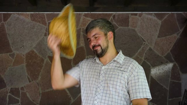 A man in a plaid shirt. Holds and removes a straw hat. Average age. Funny look. The farm. Country life. Portrait to the waist. 4K video