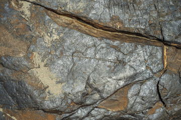 Сracked natural stone background with metal elements