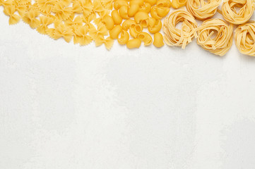 Different types of Italian pasta. Farfalle, Pipe rigate and Fettuccine on light grey background