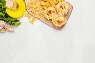 Different types of Italian pasta, fresh basil, olive oil and garlic