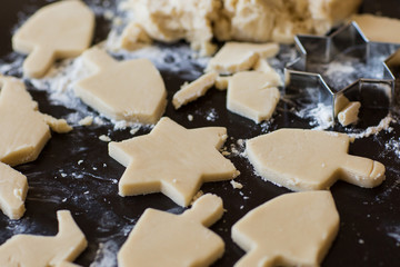 Hanukkah dreidel and star of David homemade cookie dough being cut