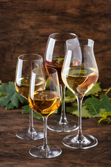 White wine set. Wine tasting, the most popular varieties of white wines in wine glasses on vintage wooden table in rustic style, selective focus