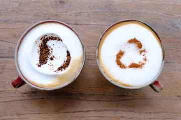 cup of coffee with cream on wooden background