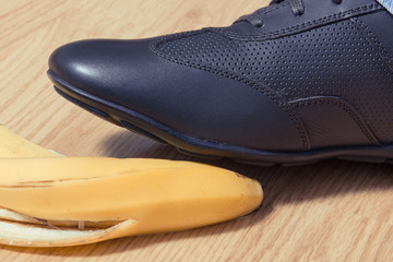 Foot in leather shoe before slipping on banana peel