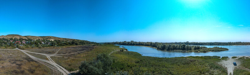 Rural landscape with a river, a forest and a Don village