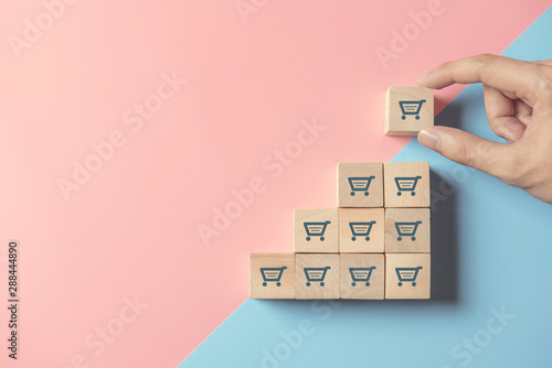 sale volume increase make business grow, hand hold cube with icon shopping cart symbol.