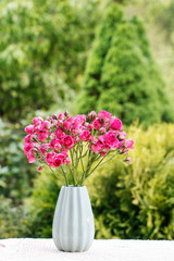 Bouquet of pink roses in blue ceramic vase. Postcard motif.