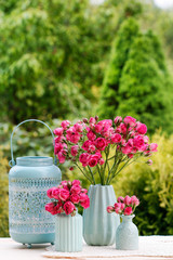 Bouquet of pink roses in blue ceramic vase. Postcard motif.