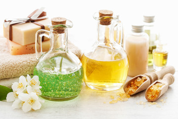 Glass bottle with liquid soap and other spa cosmetics on the table.