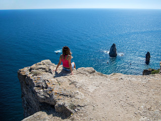 girl sitting on the edge of a cliff