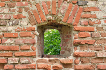 Arched window in the old red brick wall.