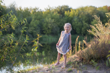 beautiful little blonde girl on summer beach