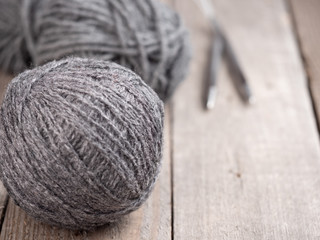 Gray wool for knitting on a wooden surface. Copy space.
