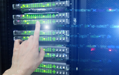 Finger pressing on server room datacenter background. Technology background.
