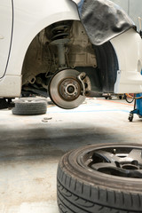 Changing a wheel , shock absorber and brake of a car in garage.