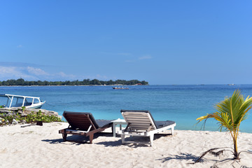 Fototapeta na wymiar Beach chairs on the white sands in Gili Meno Island, Indonesia