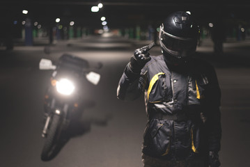 Biker is showing a middle finger on night parking.
