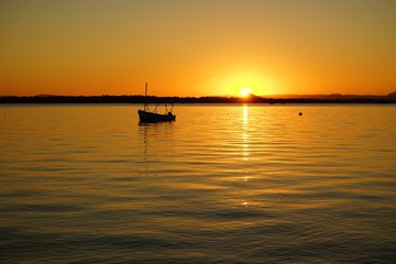 Fototapeta na wymiar sun setting over calm water